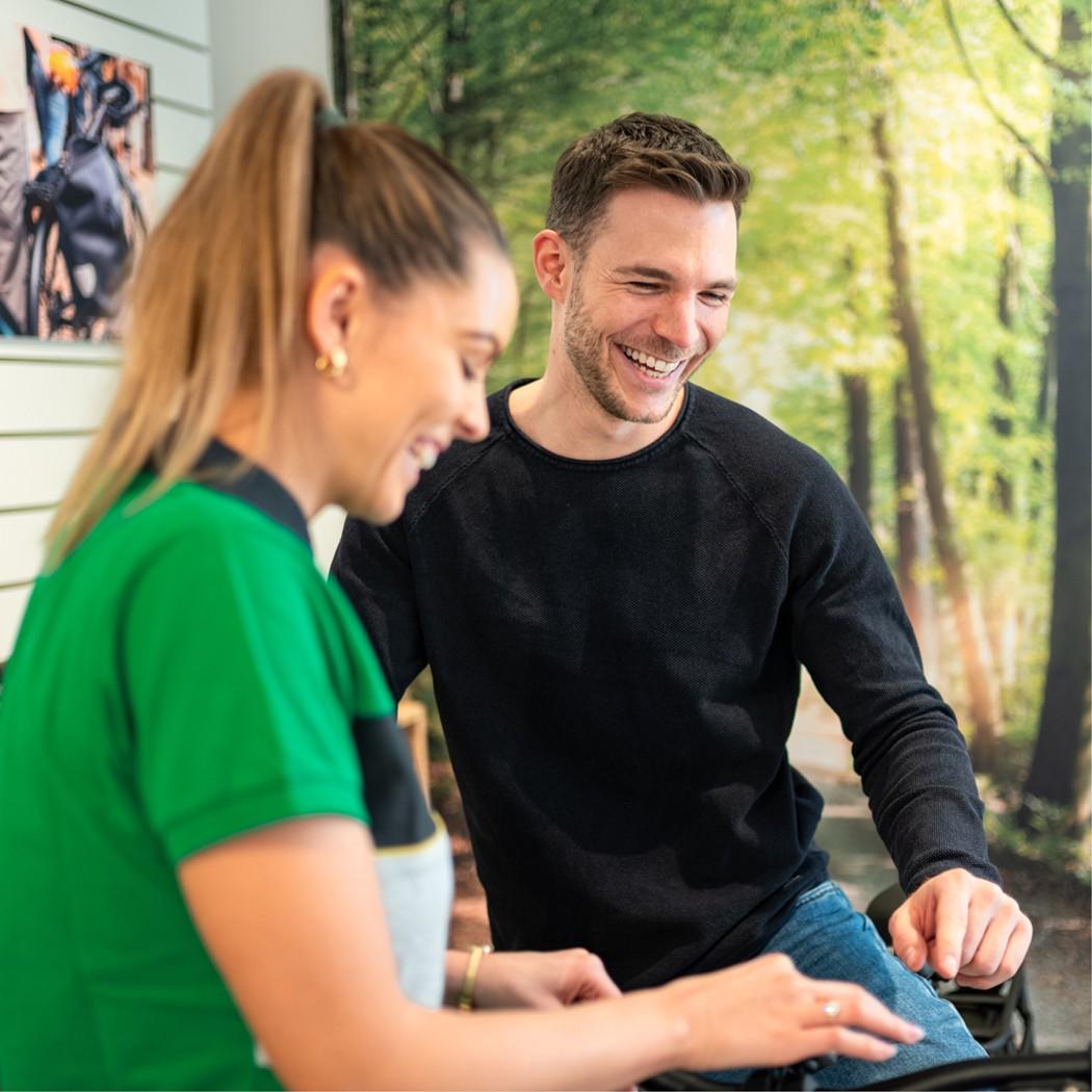 Eine e-motion Mitarbeiterin informiert einen interessierten Kunden über e-Bikes