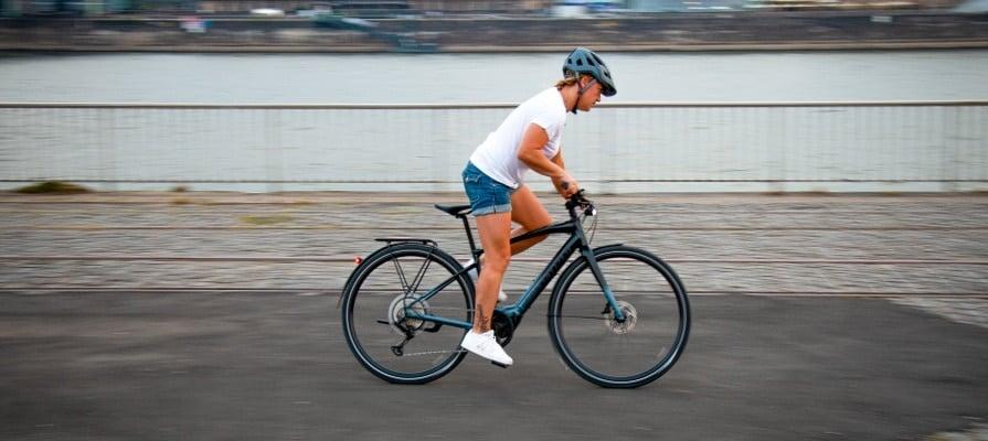 Person fährt Specialized Vado SL E-Bike entlang eines Flusses