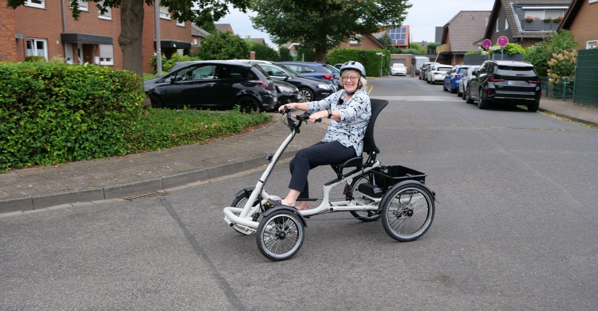 Eine Frau fährt mit ihrem Tibo+ Dreirad von pfautec durch Berlin-Steglitz.