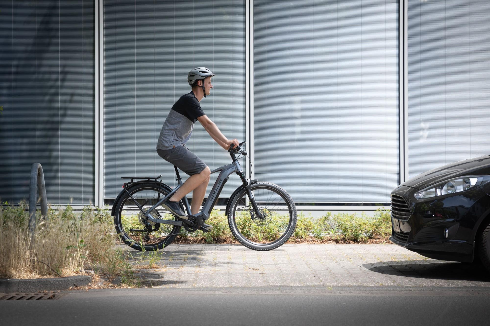 Das Bild zeigt einen Radfahrer, der auf einem Hercules Nos SUV E-Bike fährt.