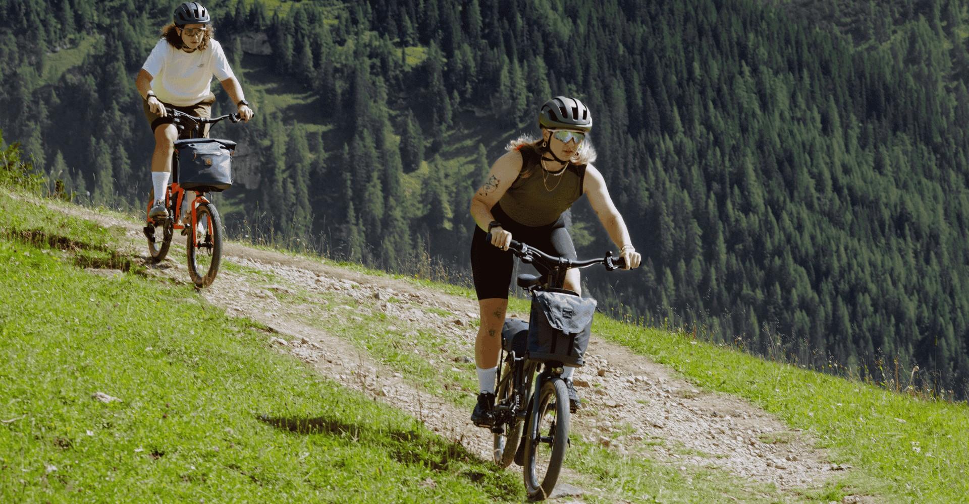 Zwei Personen fahren mit dem e-Bike von Brompton in den Bergen