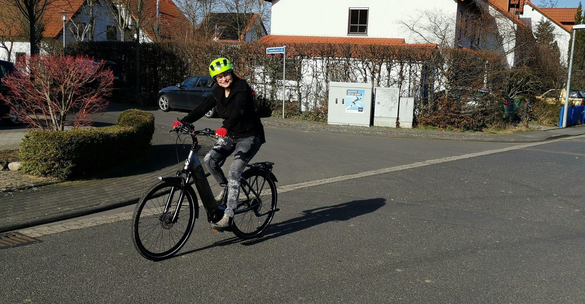 Eine Frau sitzt auf dem Giant Dailytour E+ und fährt die Straße entlang