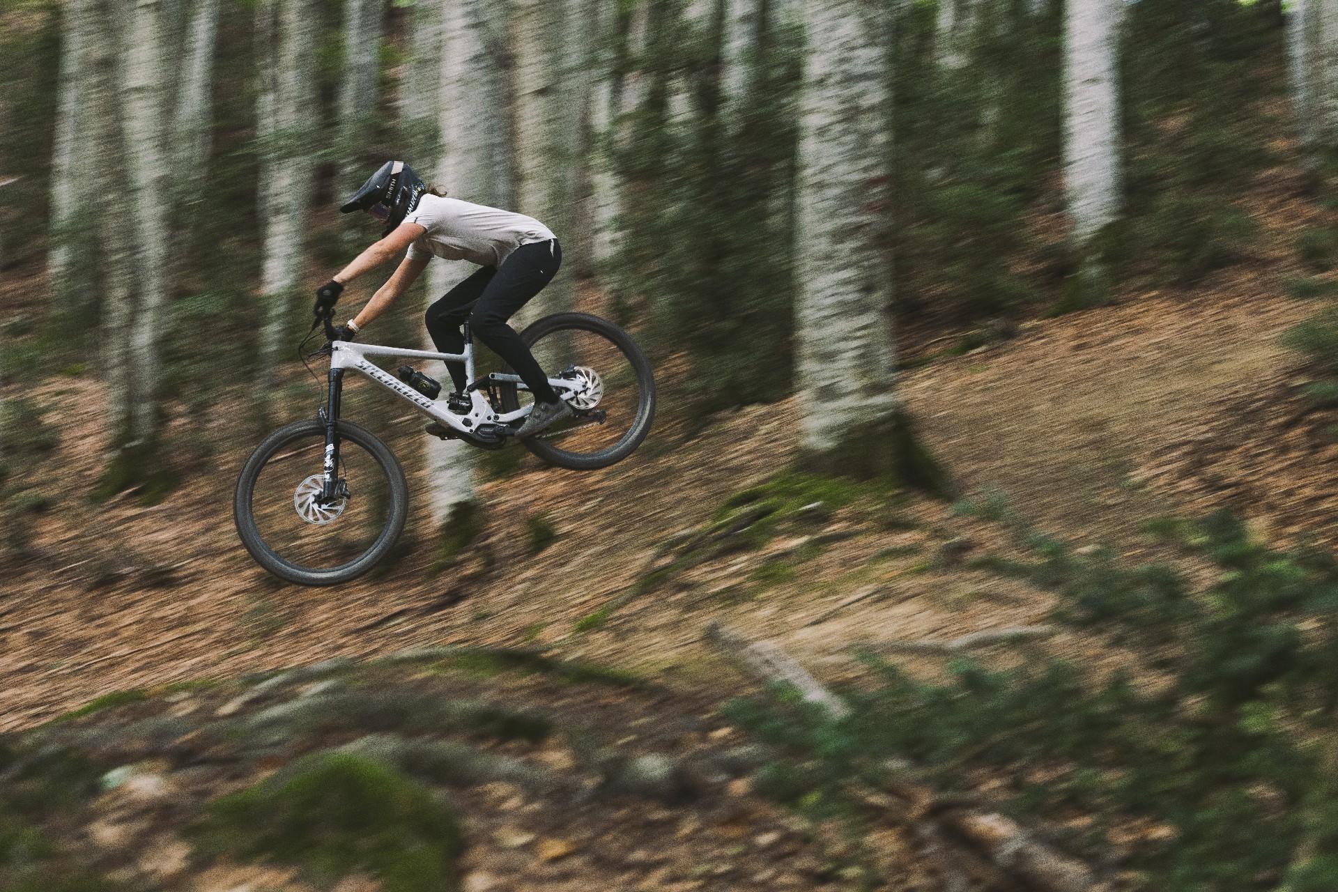 Eine Person springt mit Specialized Kenevo SL e-MTB im Wald