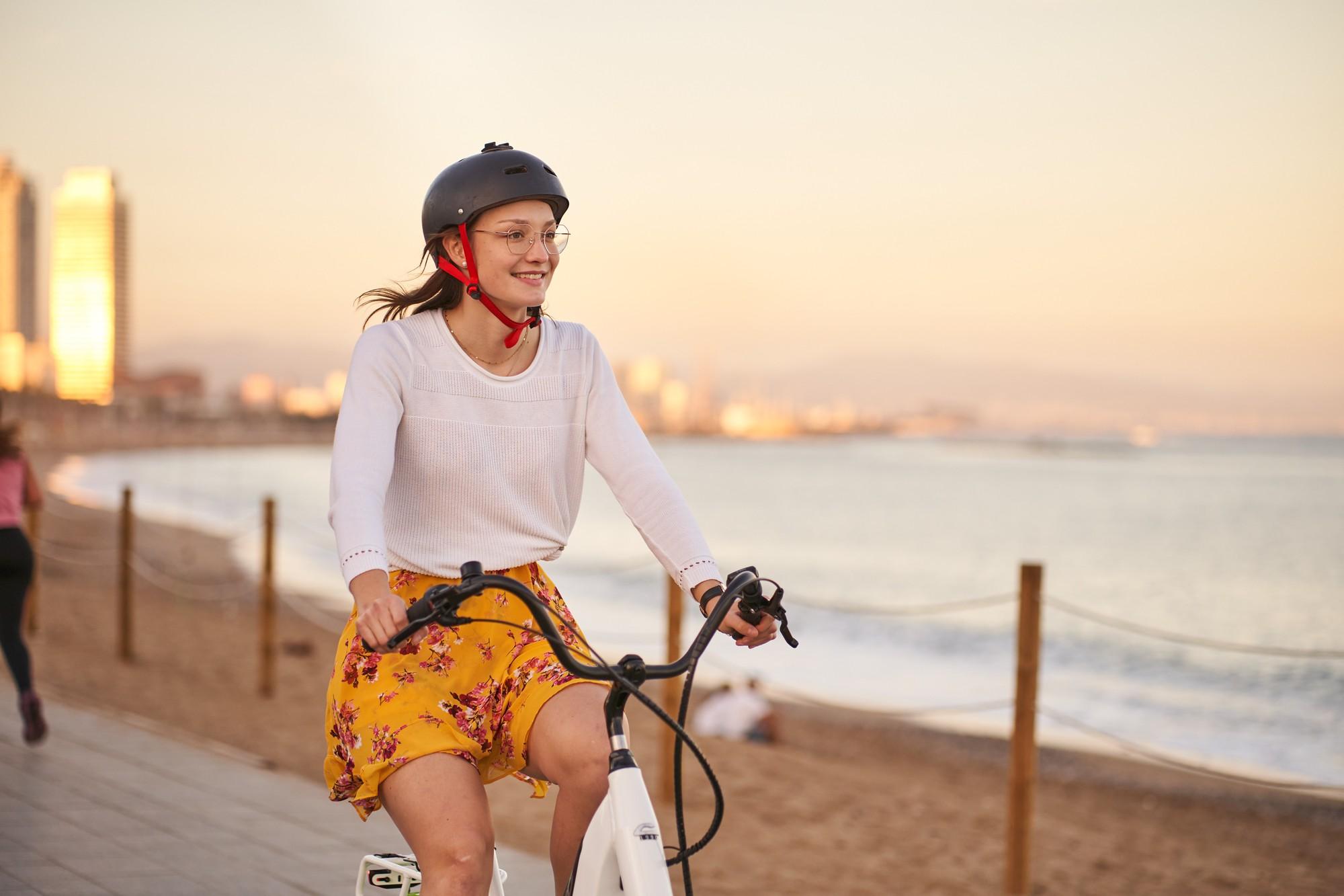 Eine frau fährt mit ihrem Corratec e-Bike über die Promenade am Strand in den Niederlanden.
