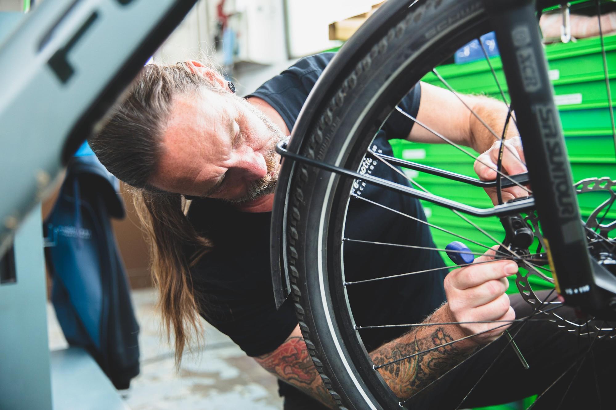 Ein Servicemitarbeiter arbeitet an einem e-Bike Reifen