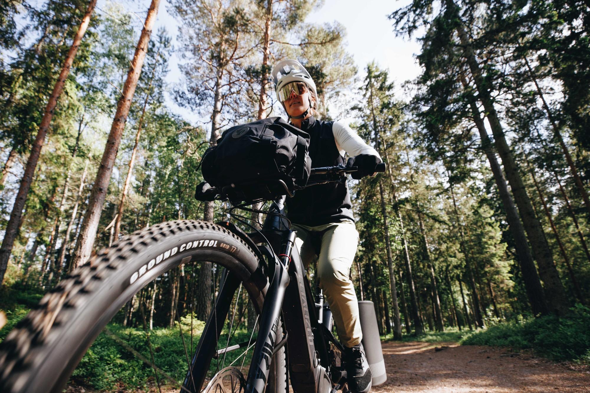 Ein Mann fährt mit seinem Specialized e-Bike und Gepäck durch den Wald