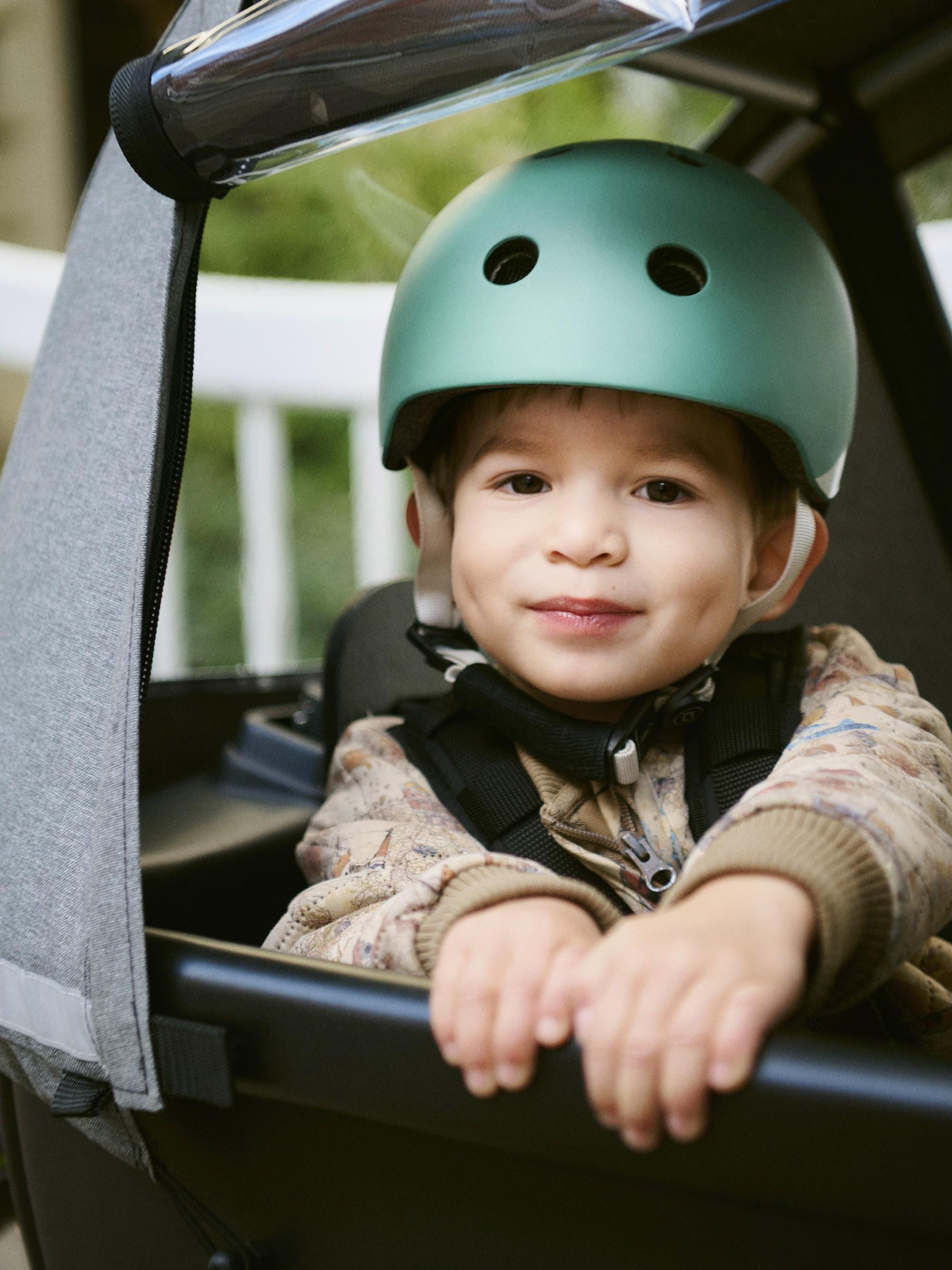 Ein Kind mit Helm sitzt in der Transportbox des Winther Lasten e-Bikes