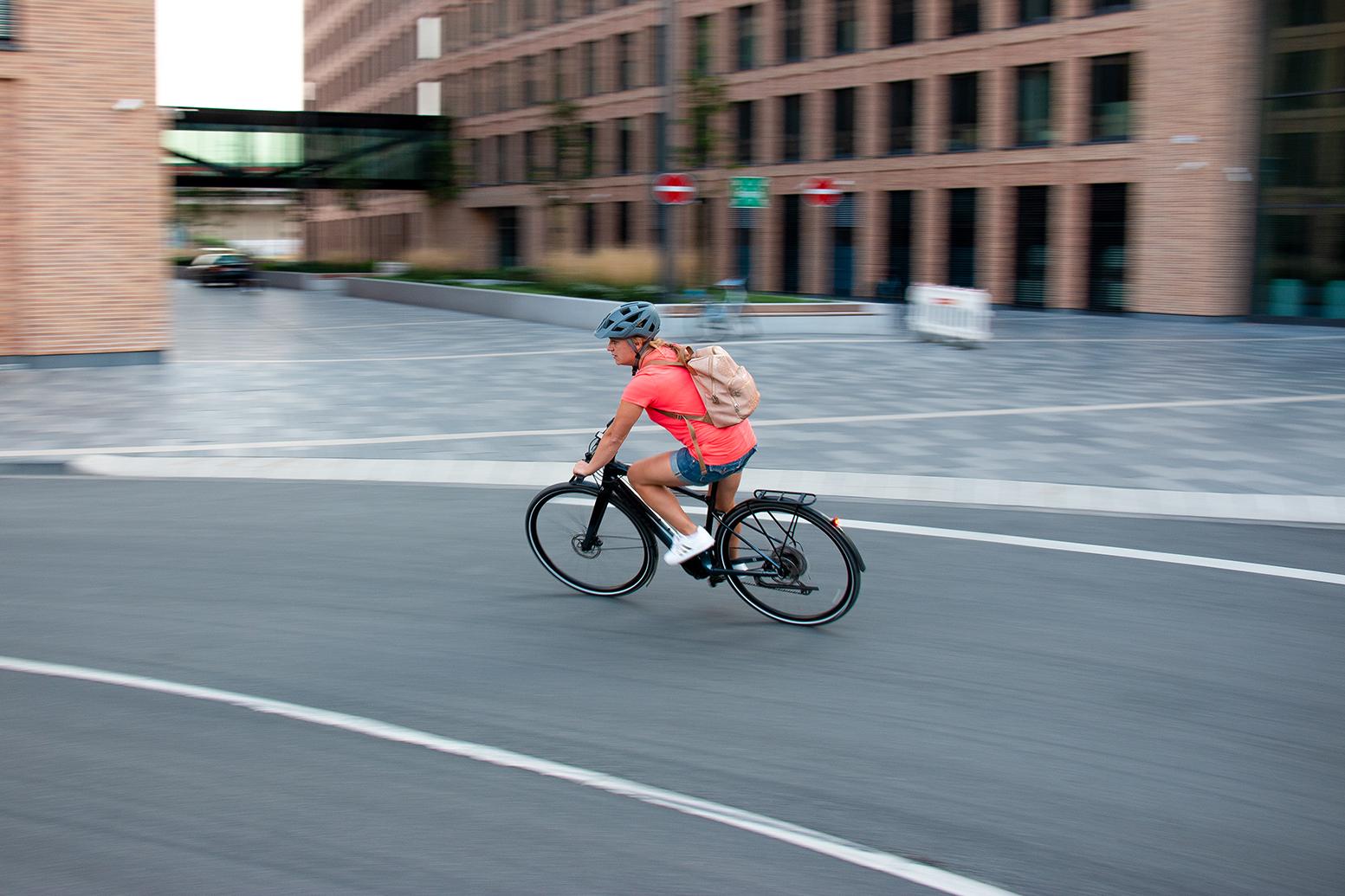 Eine Frau fährt ein Specialized Turbo Vado SL durch eine Stadt
