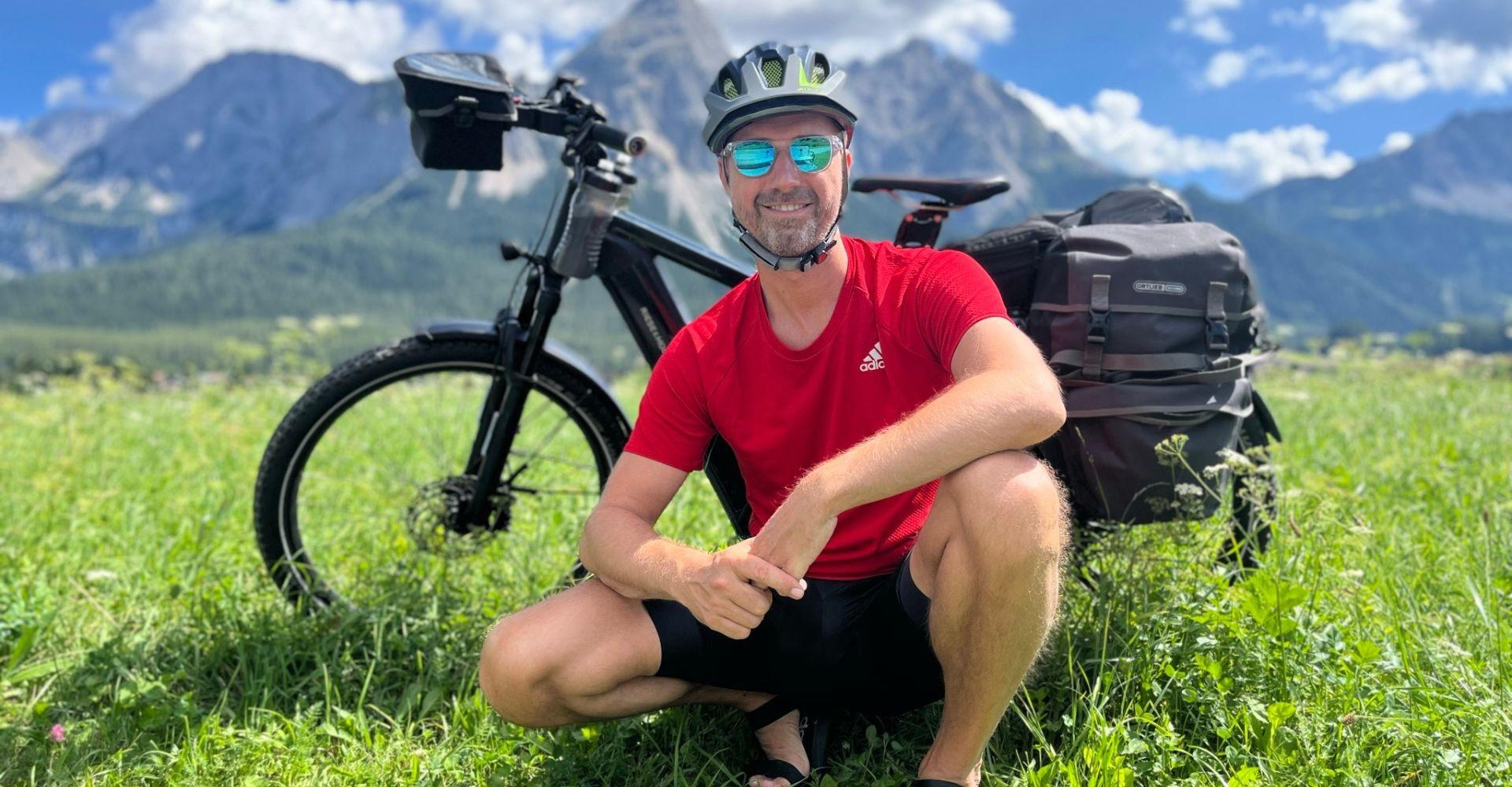 Frank aus Hamburg sitzt vor dem Charger4, im Hintergrund die Berge