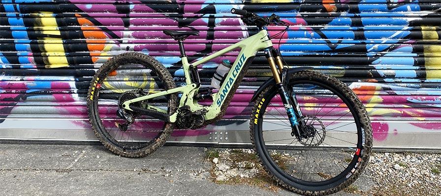 Hochwertiges Santa Cruz Mountainbike vor bunter Graffiti-Wand. Perfekt für Abenteuer im Gelände.