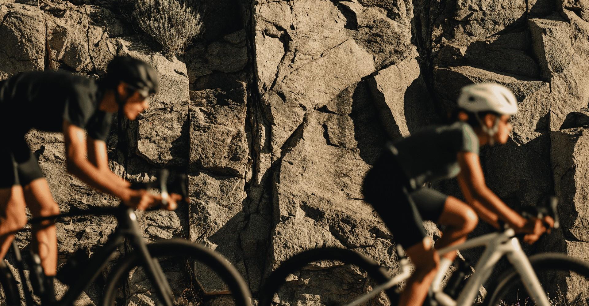 Das Bild zeigt zwei Radfahrer auf Specialized Turbo Creo 2 e-Bikes, die dynamisch eine felsige Landschaft entlangfa