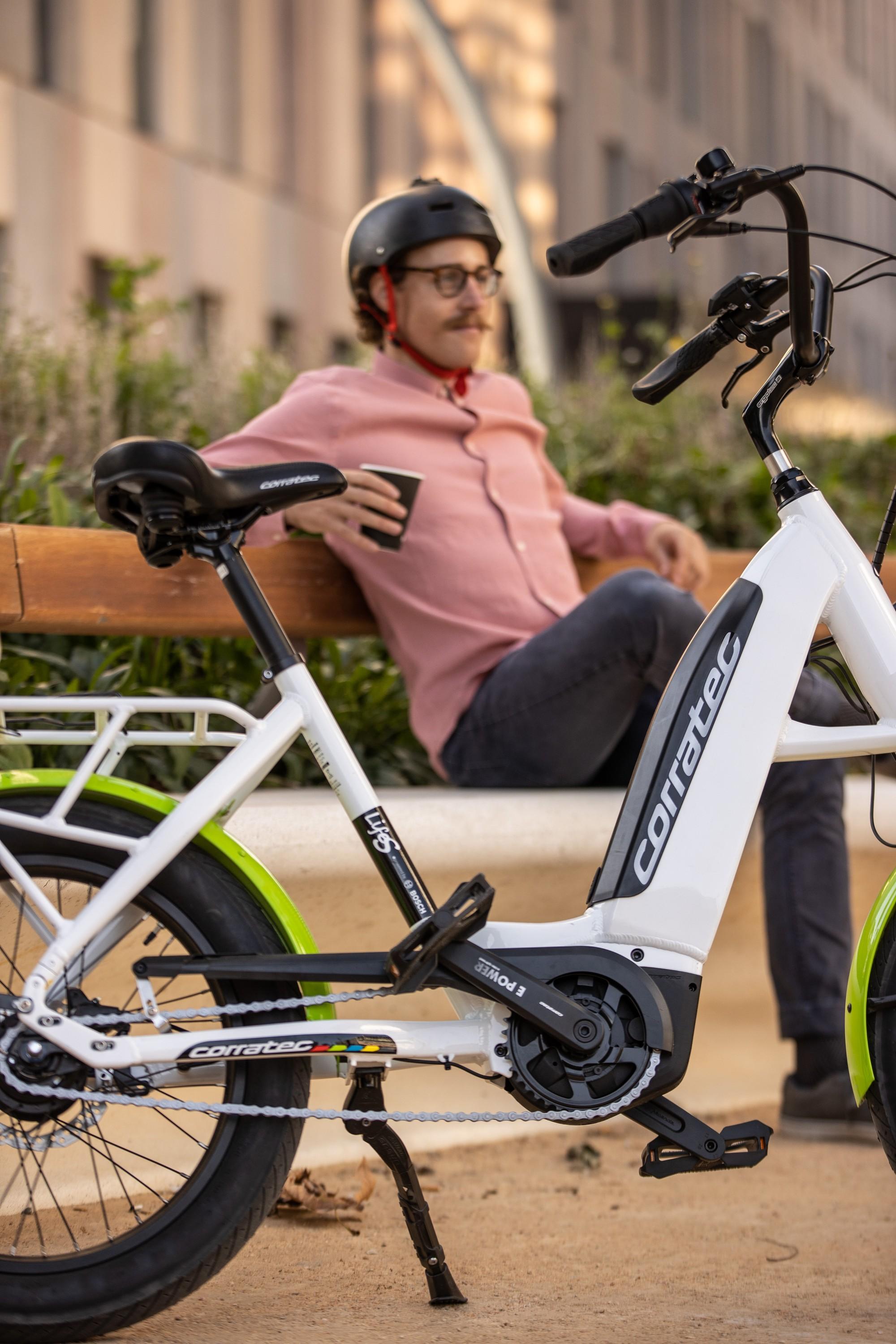 Ein Mann sitzt auf einer Bank, vor ihm ein Corratec e-Bike