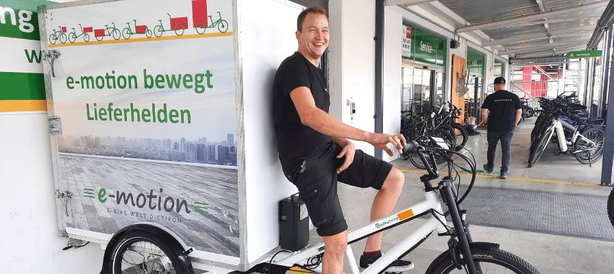 Mann auf e-motion Lastenrad vor einem Lieferwagen