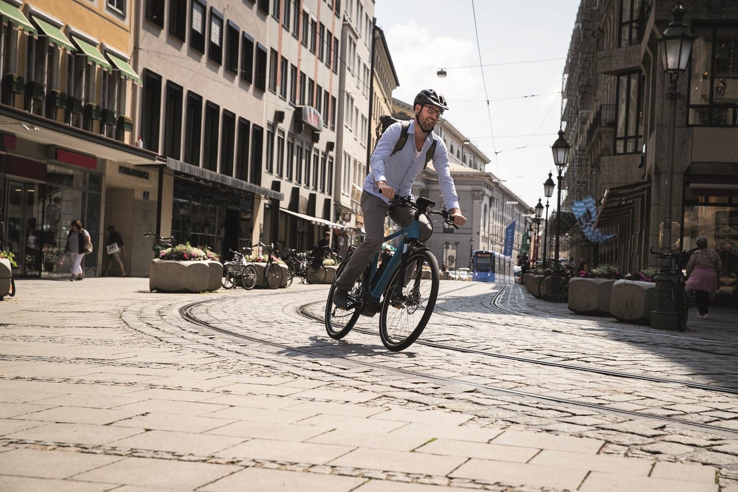 Ein Mann fährt mit Bosch e-Bike auf den Schienen im urbanen Umfeld
