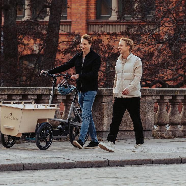 Zwei Männer schieben das Johansson Lasten e-Bike über eine Brücke