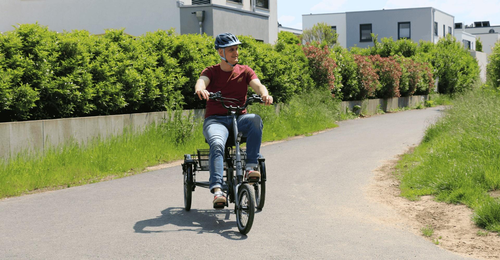 Ein Mann ist mit dem pfautec Scoobo e-Dreirad unterwegs.