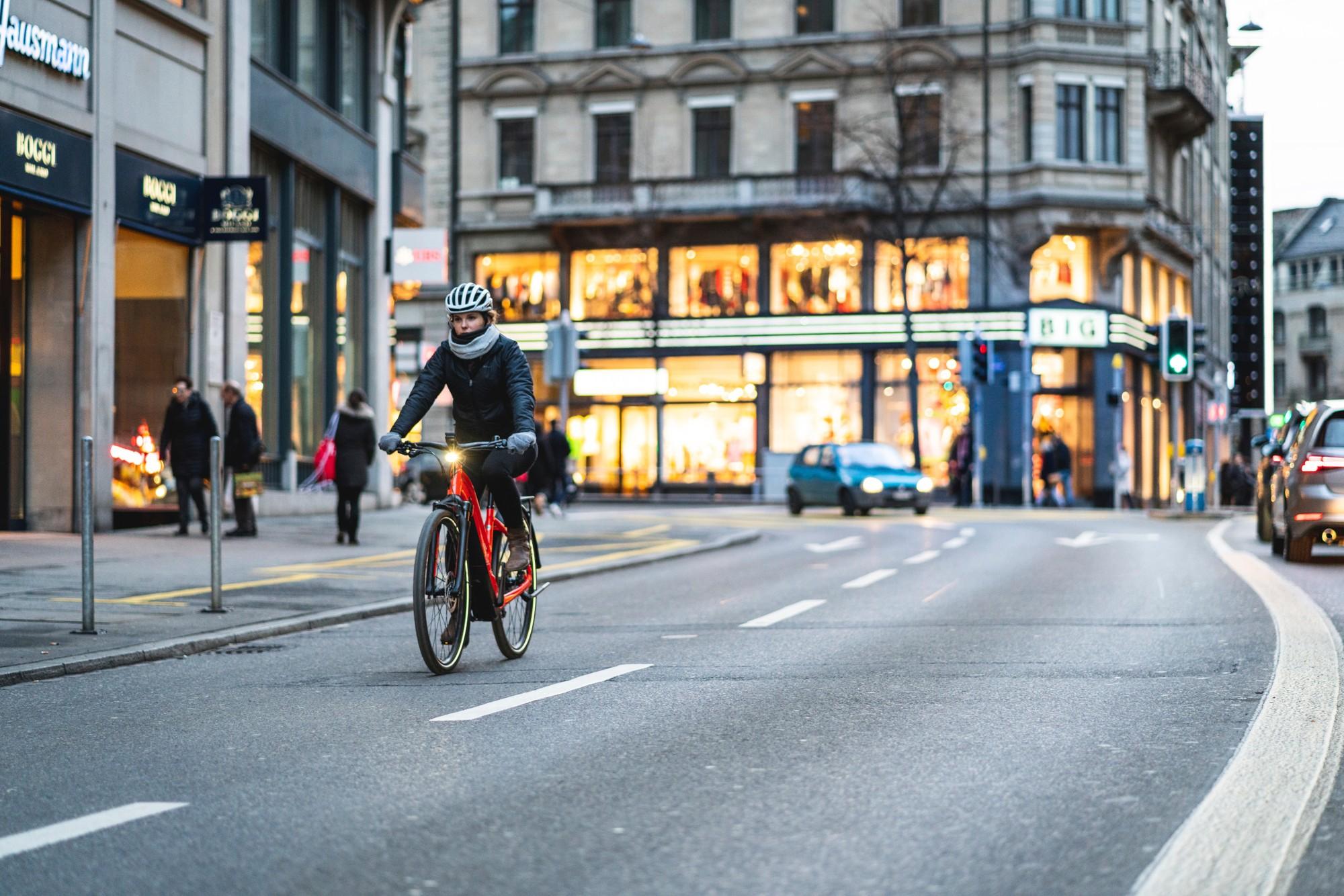 Frau fährt mit ihrem Turbo Vado Experience durch die Stadt um dem Stau zu entkommen.