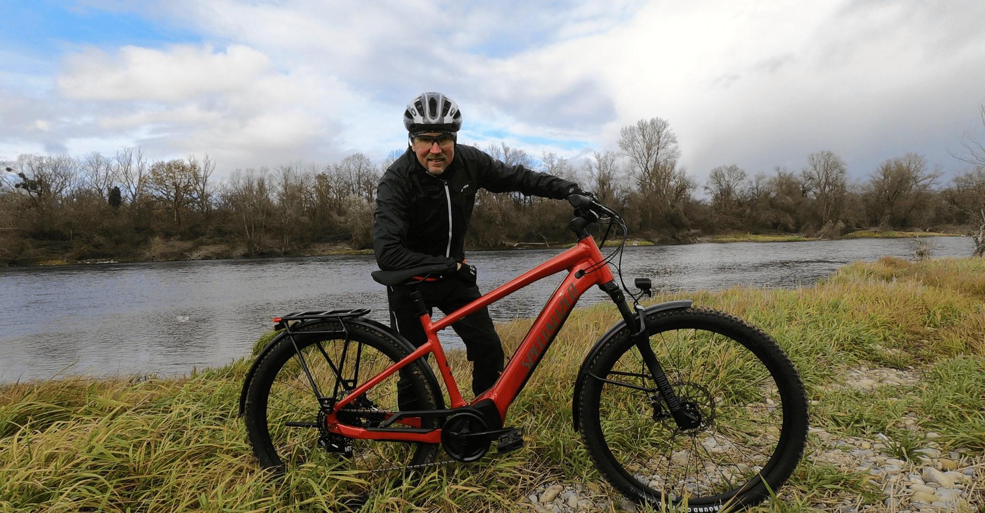 Christof Steier steht hinter dem Specialized Turbo Tero vor dem Wasser auf der Wiese
