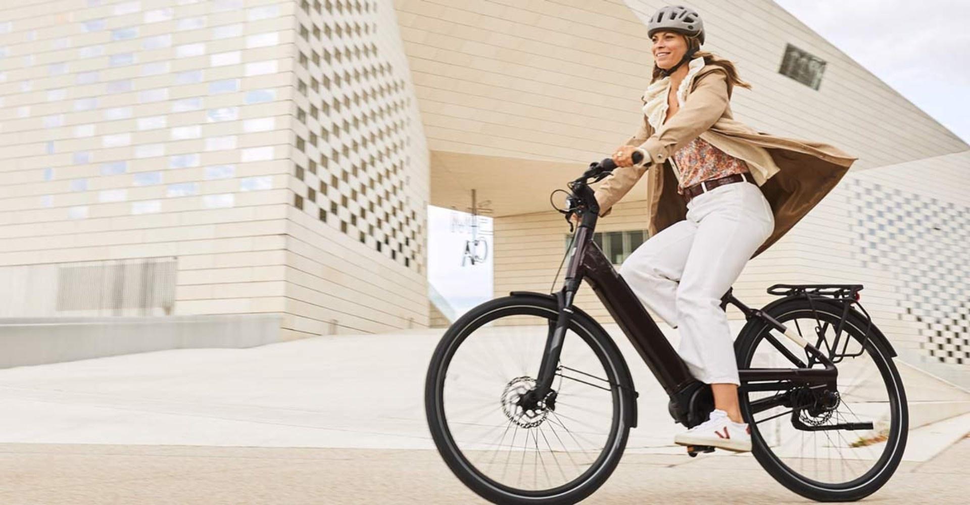 Eine Frau ist mit ihrem Liv Allure E+ e-Bike zum Saisonstart 2020 im Frühling in der Stadt unterwegs.