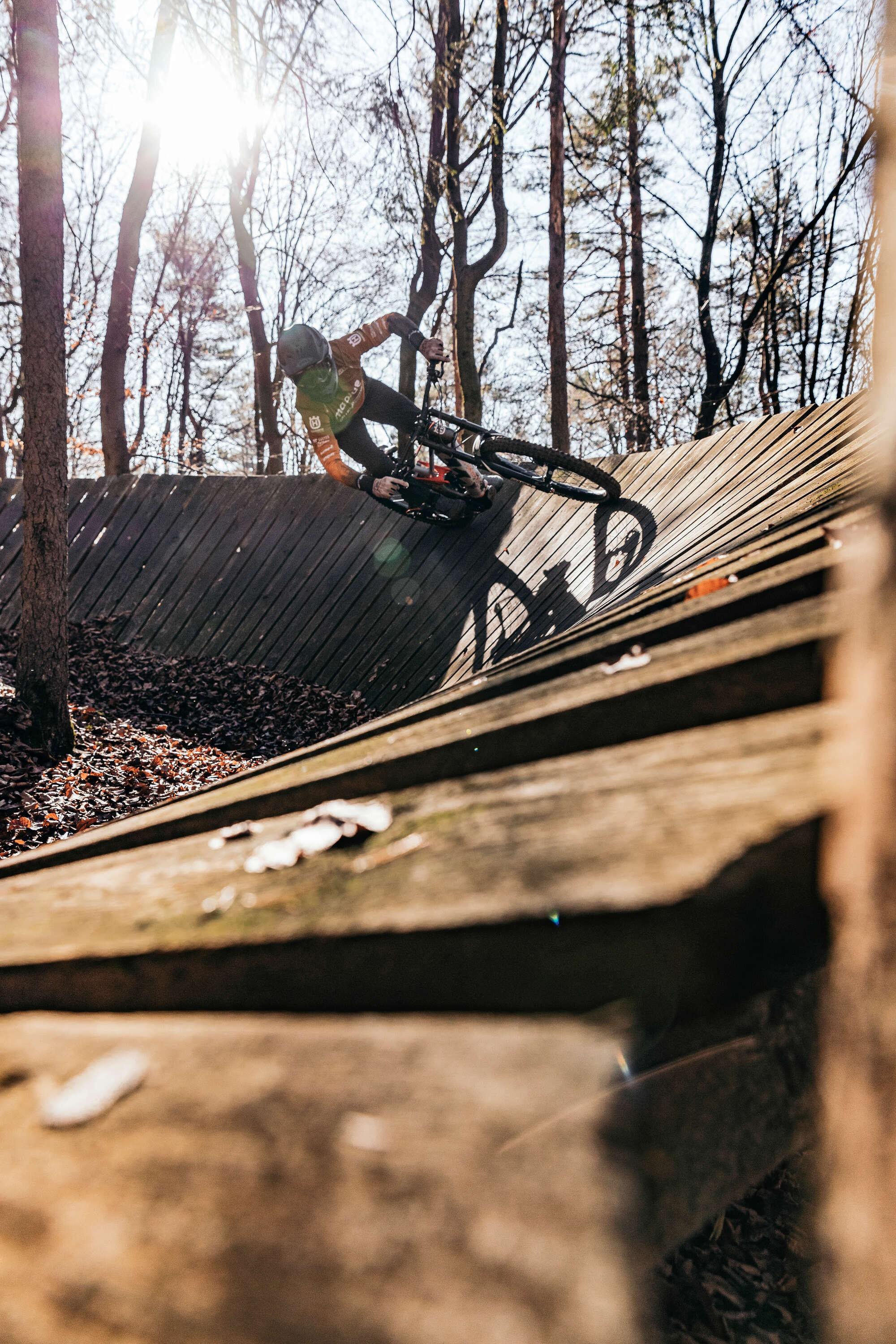 Ein Fahrer fährt mit einem Husqvarna e-Bike auf der Holzrampe