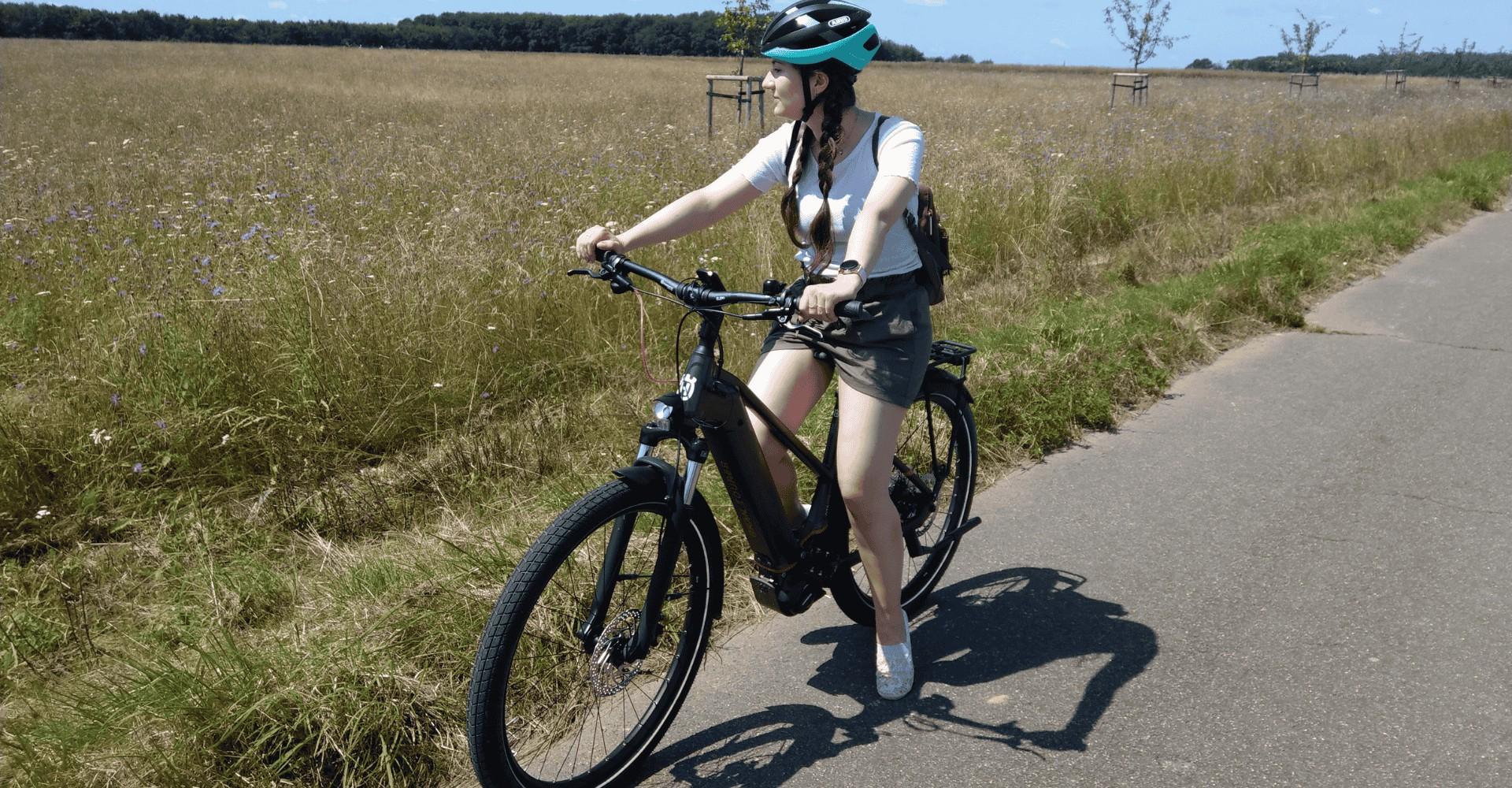 Lisa sitzt auf de Husqvarna Gran Tourer 5 neben einem Feldweg