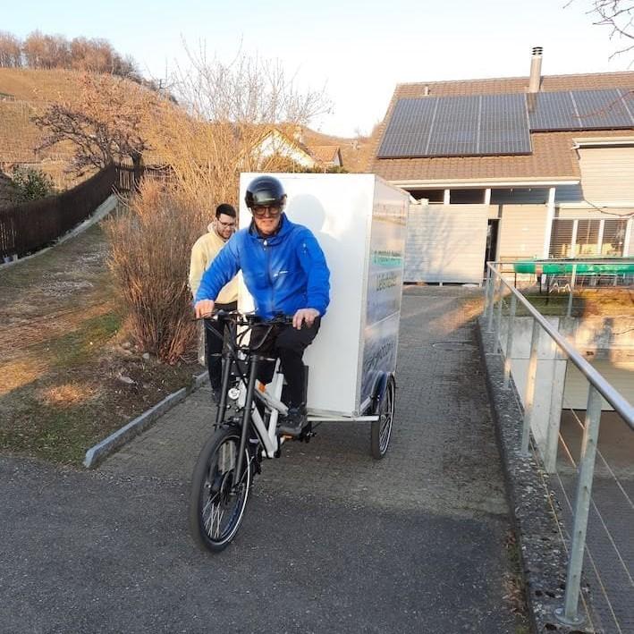 Dreirädrige Radkutsche mit zwei Personen auf ländlicher Straße