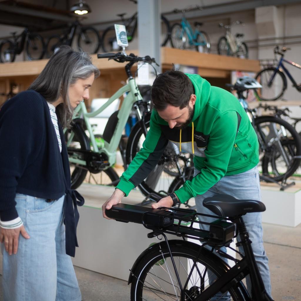 Ein Mitarbeiter der e-motion e-bike Welt in Oberhausen berät eine Kundin zum e-Bike Akku.