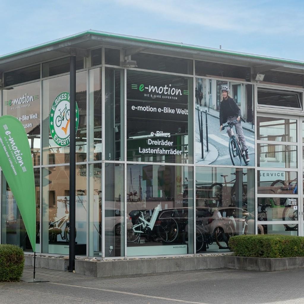 Das Bild zeigt ein modernes E-Bike Fachgeschäft mit großen Glasfenstern