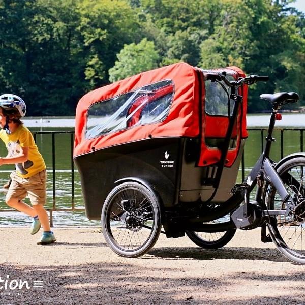 Lasten-E-Bike von Riese & Müller vor einem See mit spielendem Kind