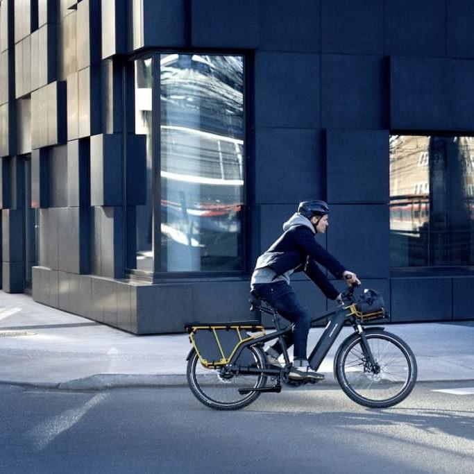 Person fährt Riese & Müller Multicharger E-Bike in urbaner Umgebung