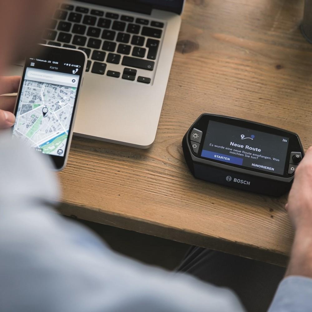 Bosch Innovationen: Auf dem Tisch liegt ein Handy, Laptop und der Bosch Bordcomputer