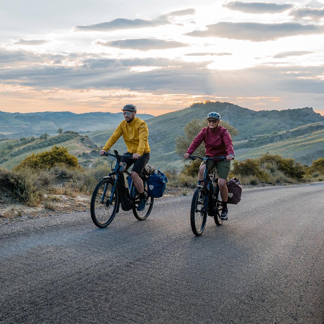 Zwei Männer machen mit ihren e-Bikes mit Bosch Motor eine Radtour durch die Berge.