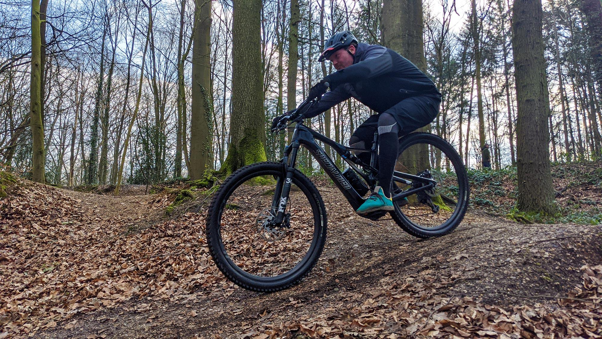 Ein Mann sitzt auf einem Specialized Turbo Levo SL und fährt durch einen Wald