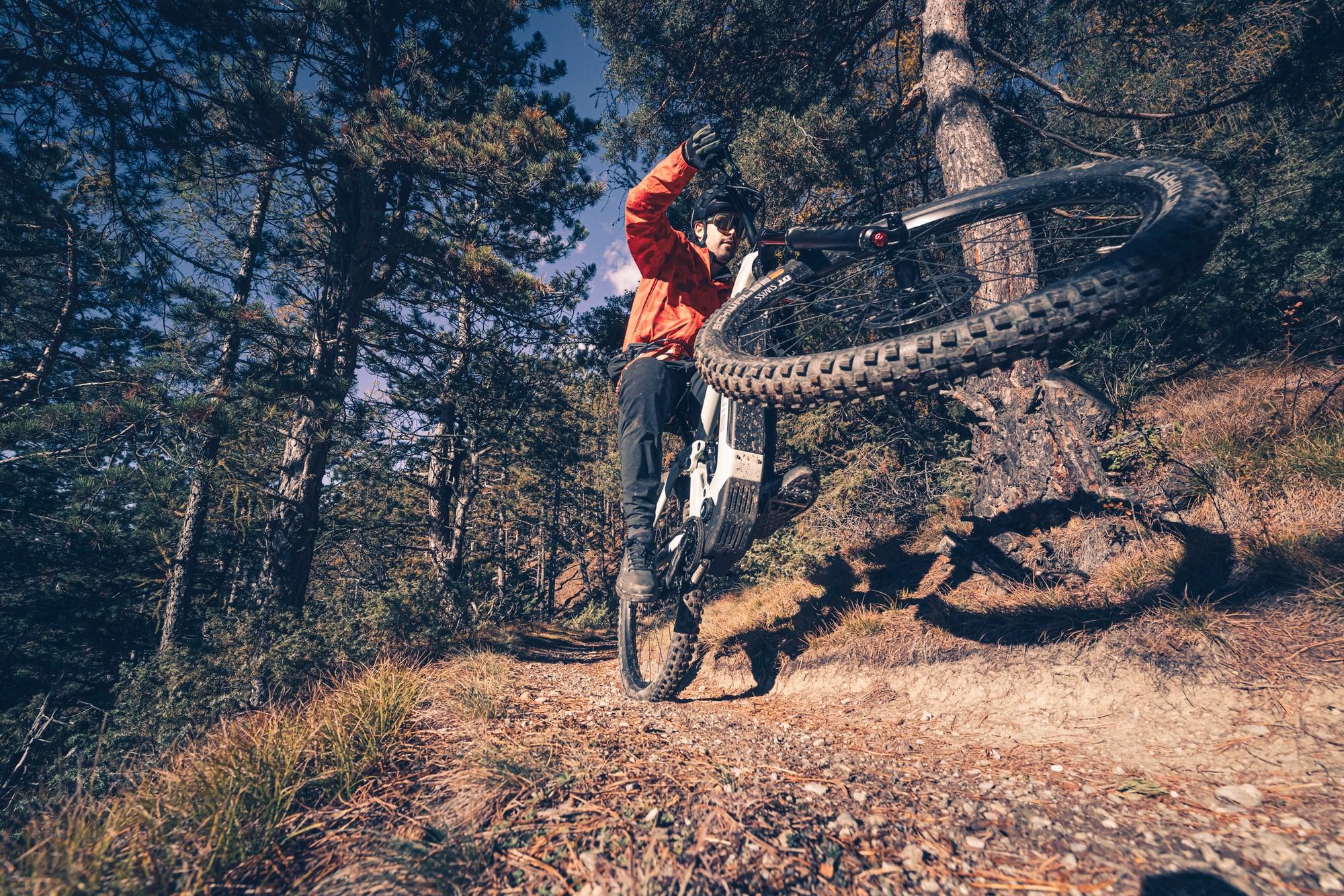 Mann fährt mit seinem e-Mountanbike einen steilen Abhang runter.