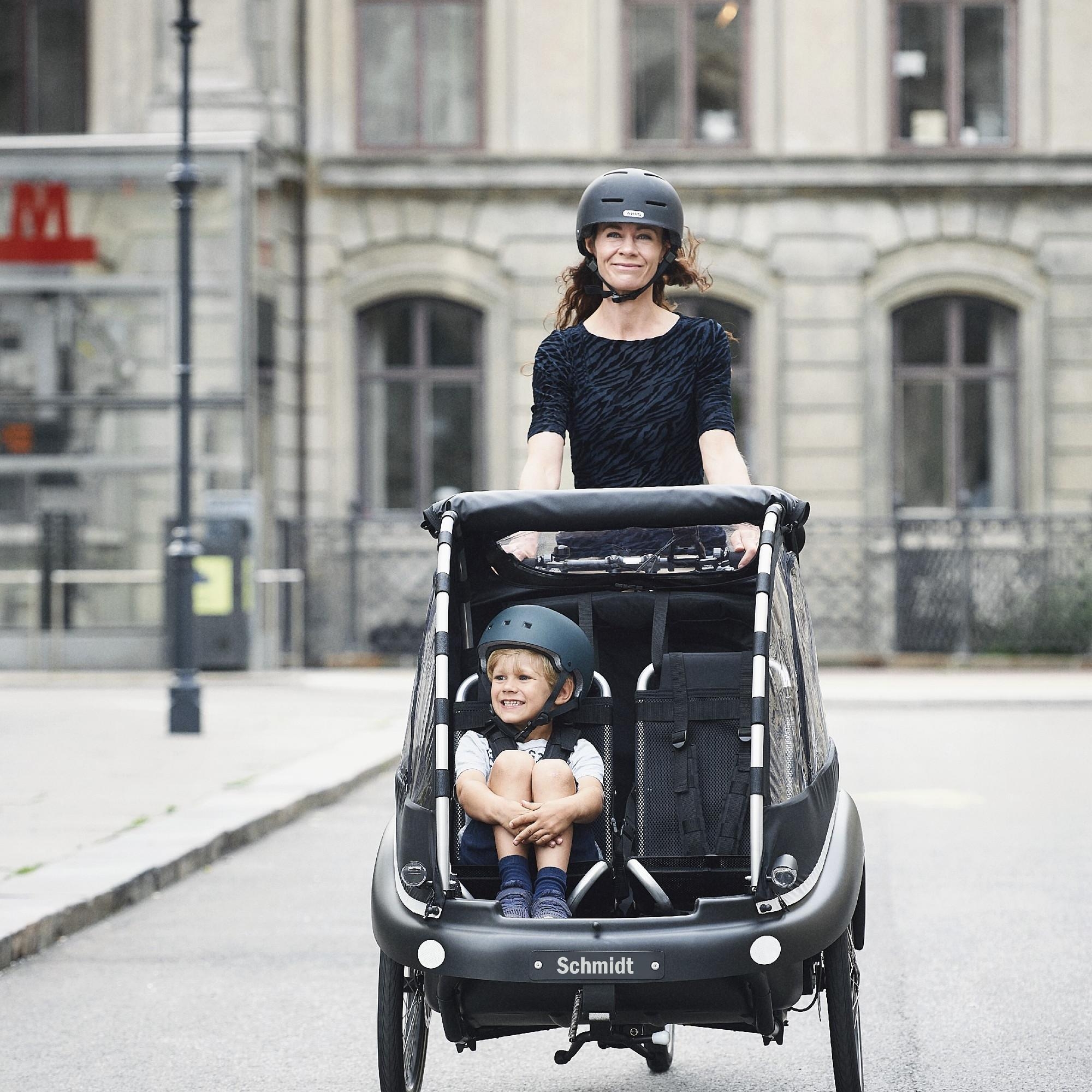 Ein Winter Kangaroo Luxe Lasten e-Bike fährt mit Kindern drin durch die Stadt im Kreis Groß-Gerau.