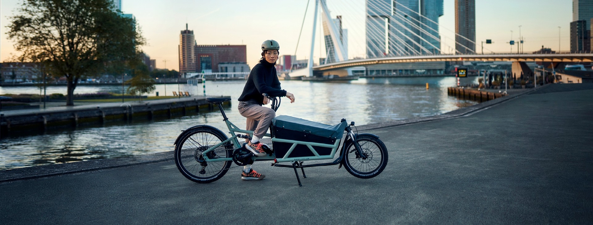 Eine Frau steht mit dem Riese & Müller Load 60 Lastenrad am Wasser