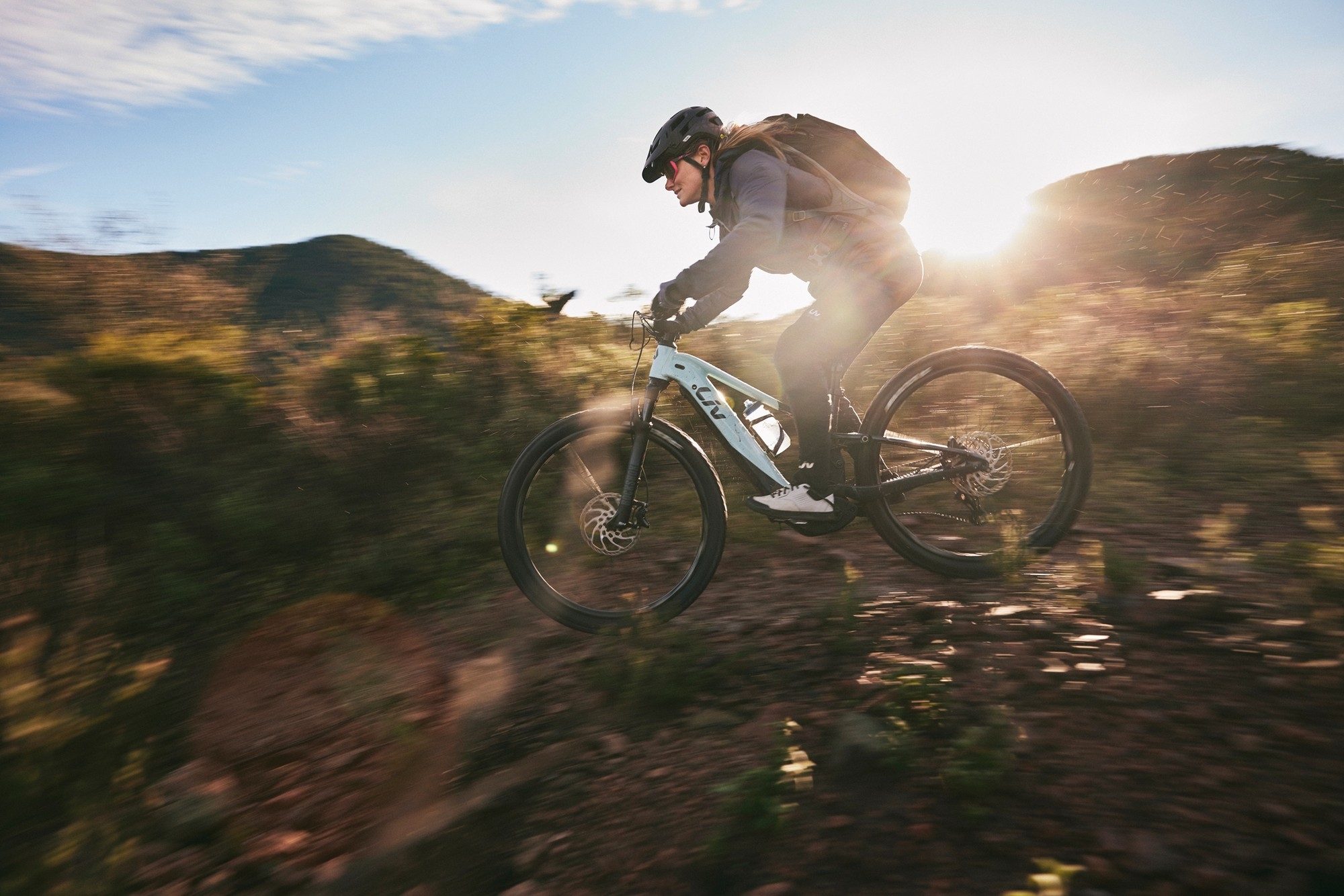 Das Bild zeigt eine Frau, die auf einem E-Bike des Modells LIV EMBOLDEN E+ 2023 fährt.