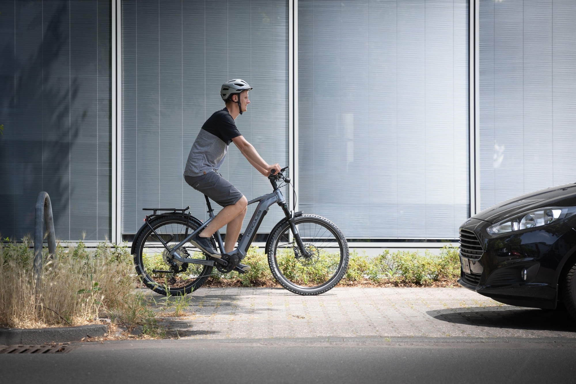 Das Bild zeigt einen Radfahrer, der auf einem Hercules Nos SUV E-Bike fährt.