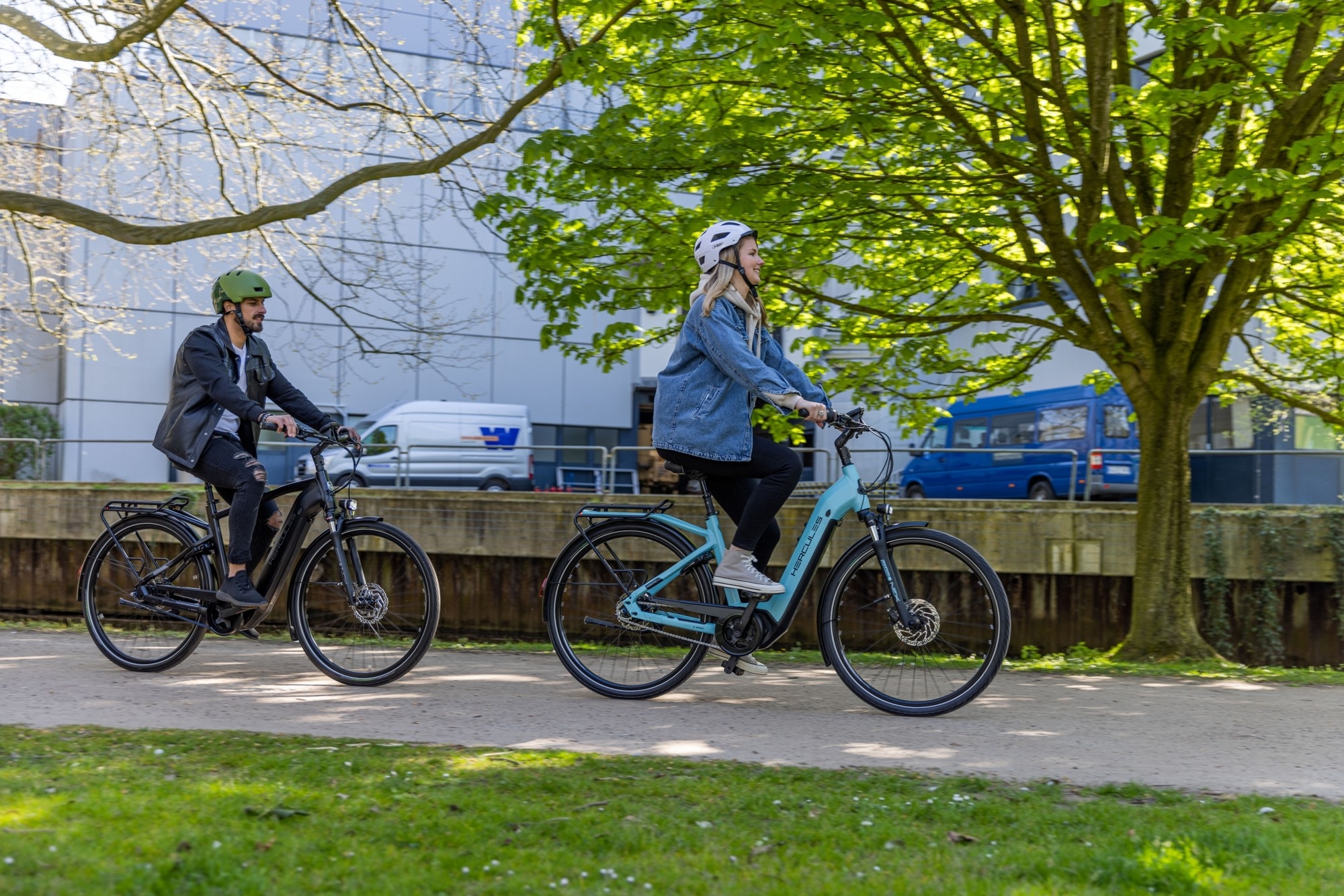 Das Bild zeigt zwei Personen auf e-Bikes von Hercules aus der Modellreihe Robert/-a