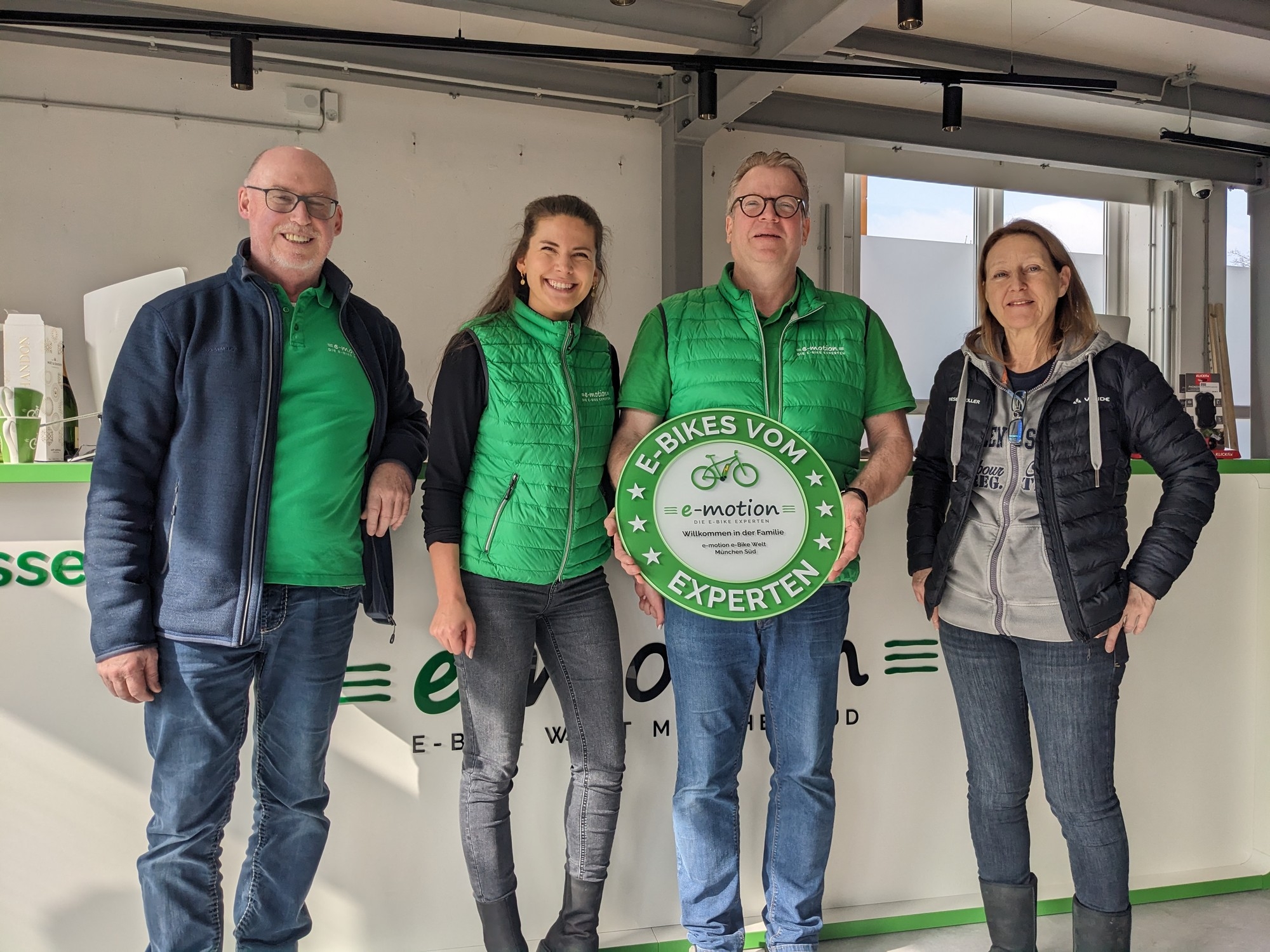 Das Bild zeigt die Eröffnung des e-motion E-Bike-Shops in München Süd, bei der vier Personen posieren.