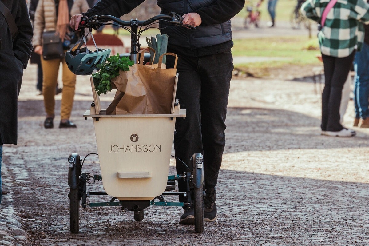 Das Bild zeigt ein E-Bike Lastenrad der Marke Johansson, das mit einer stabilen Holzbox ausgestattet ist.