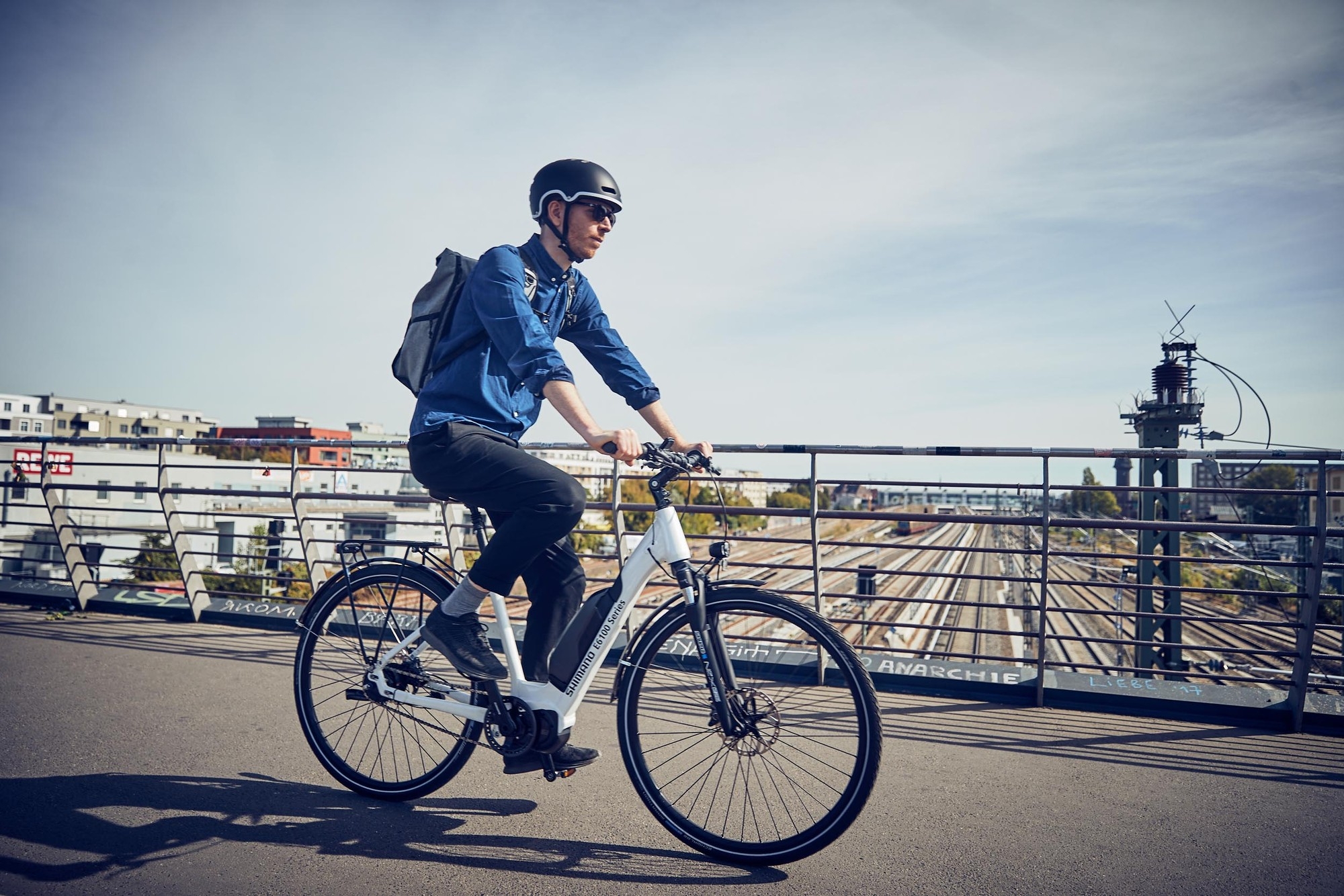 Mann fährt mit seinem City e-Bike mit einem Shimano Steps E6100 Antrieb durch die Stadt.