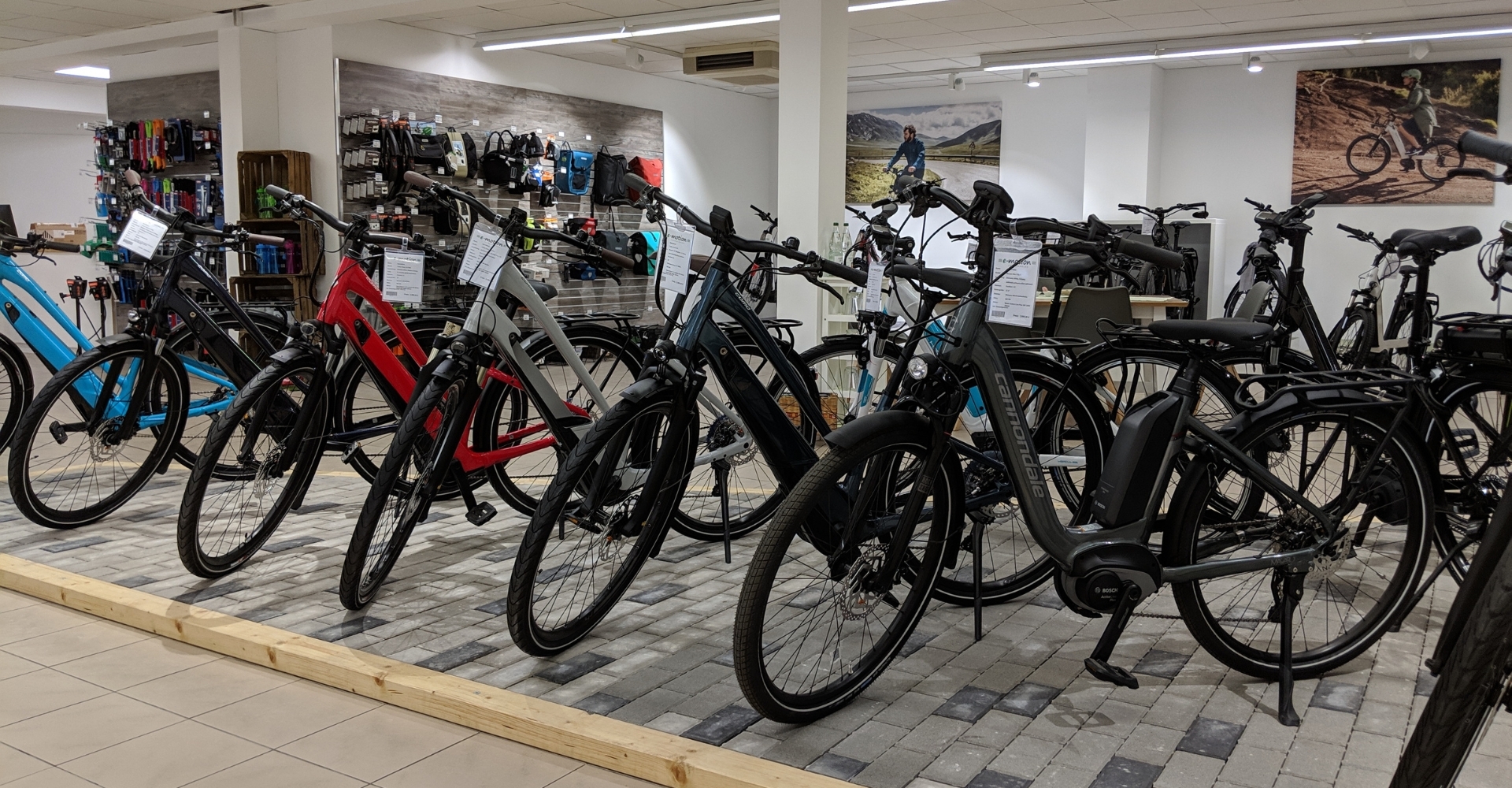 Ein Foto vom Verkaufsraum der e-motion e-Bike-Welt Fuchstal 2021. Im Vordergrund e-Bikes, im Hintergrund Zubehör