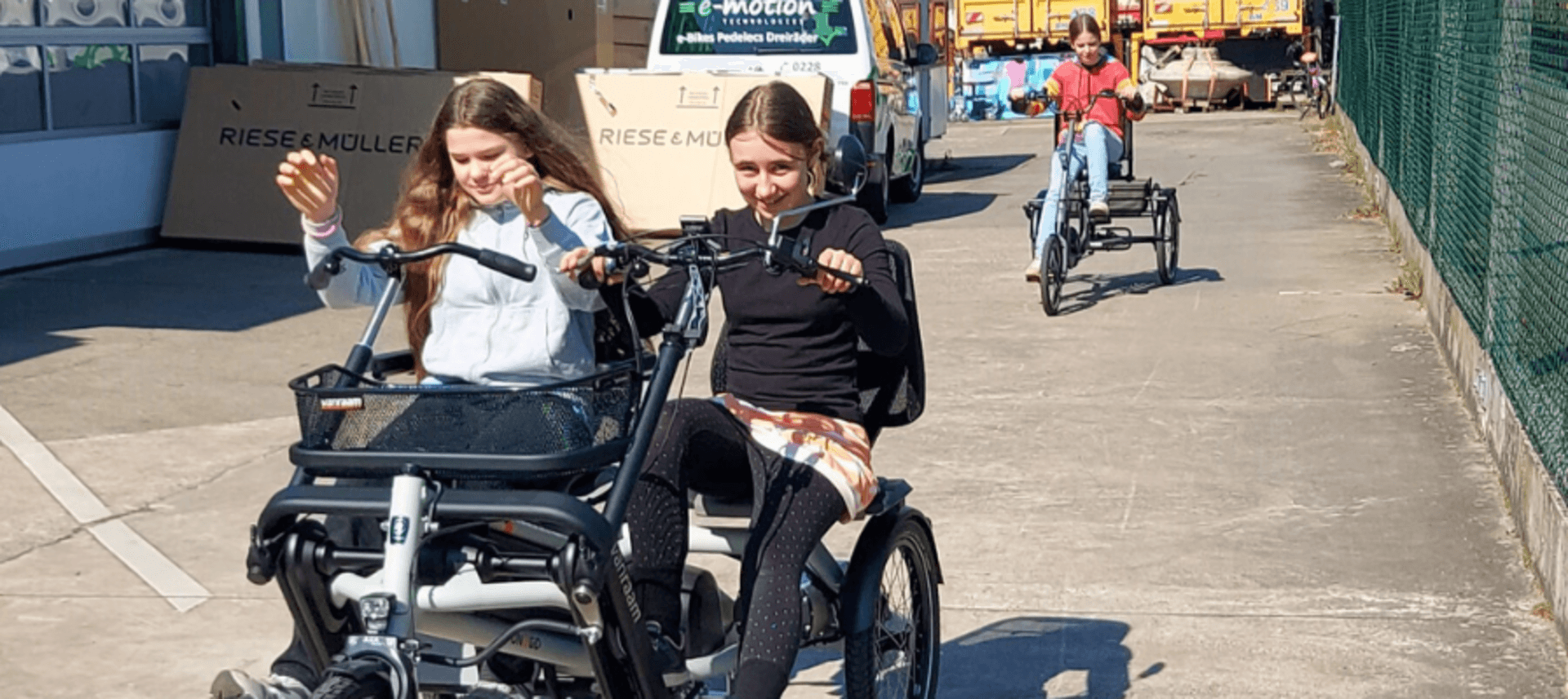 Zwei Mädchen testen ein Dreirad für zwei Personen auf dem Girls Day 2015 in Köln.