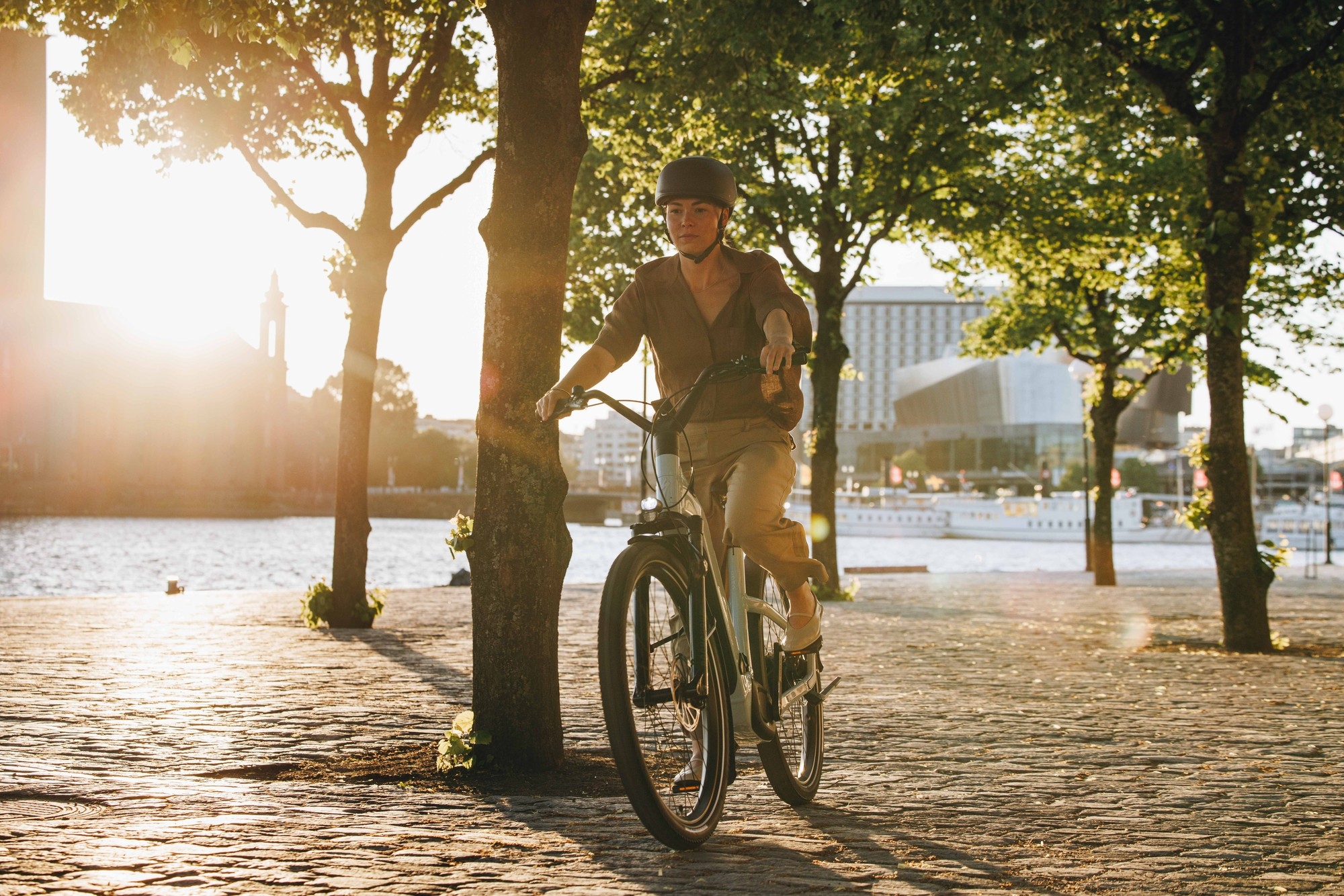 Das Bild zeigt ein Specialized Turbo Como E-Bike, das in einer malerischen urbanen Landschaft fährt.