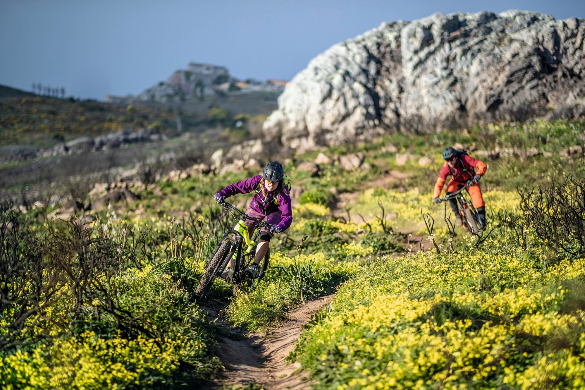 Zwei Radfahrer fahren mit ihren Haibike e-Mountainbikes actionreich eine Piste auf dem Berg runter.