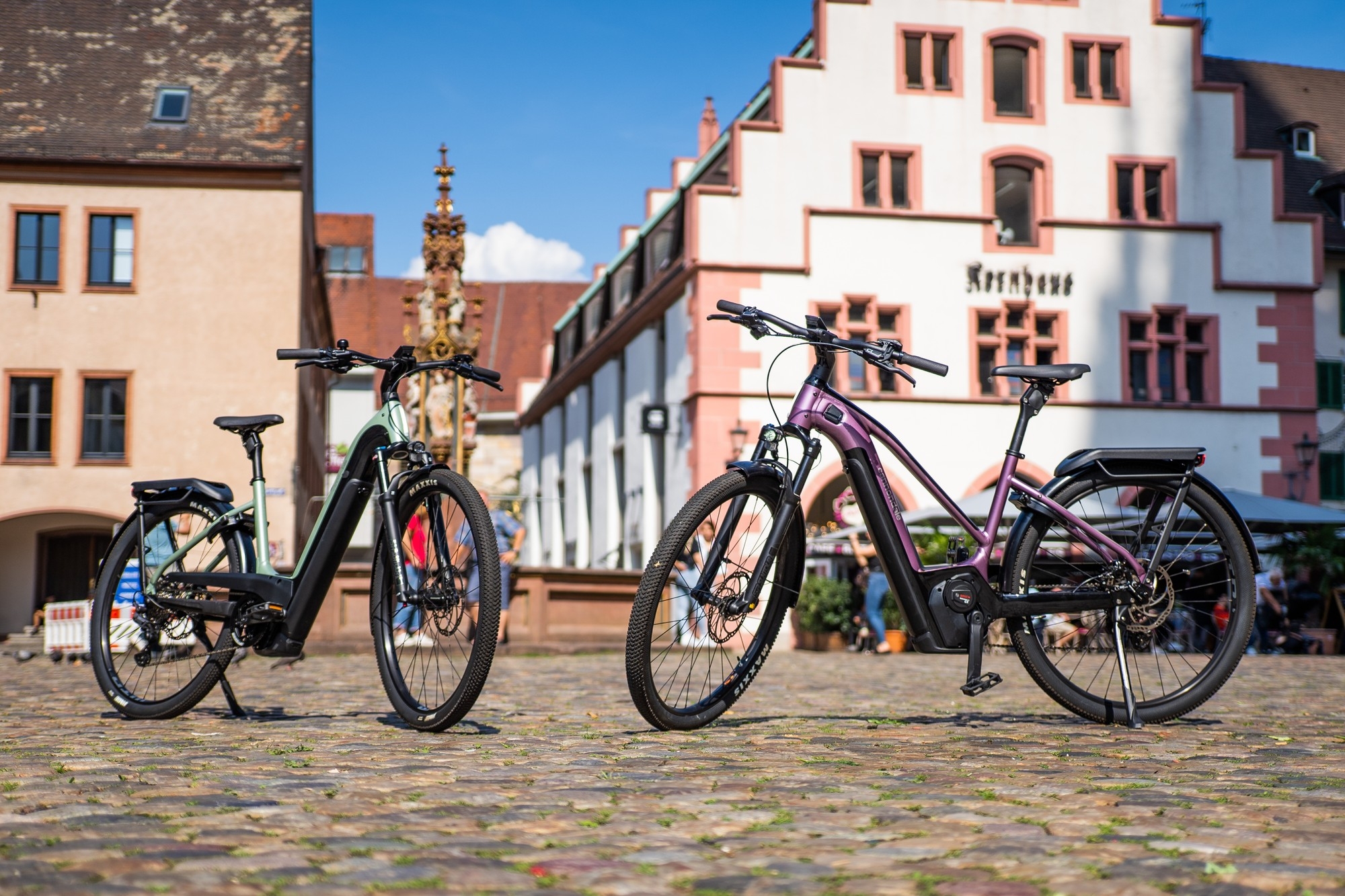 Zwei Tesoro NEO X1 e-Bikes stehen in Ulm vor urbaner Kulisse.
