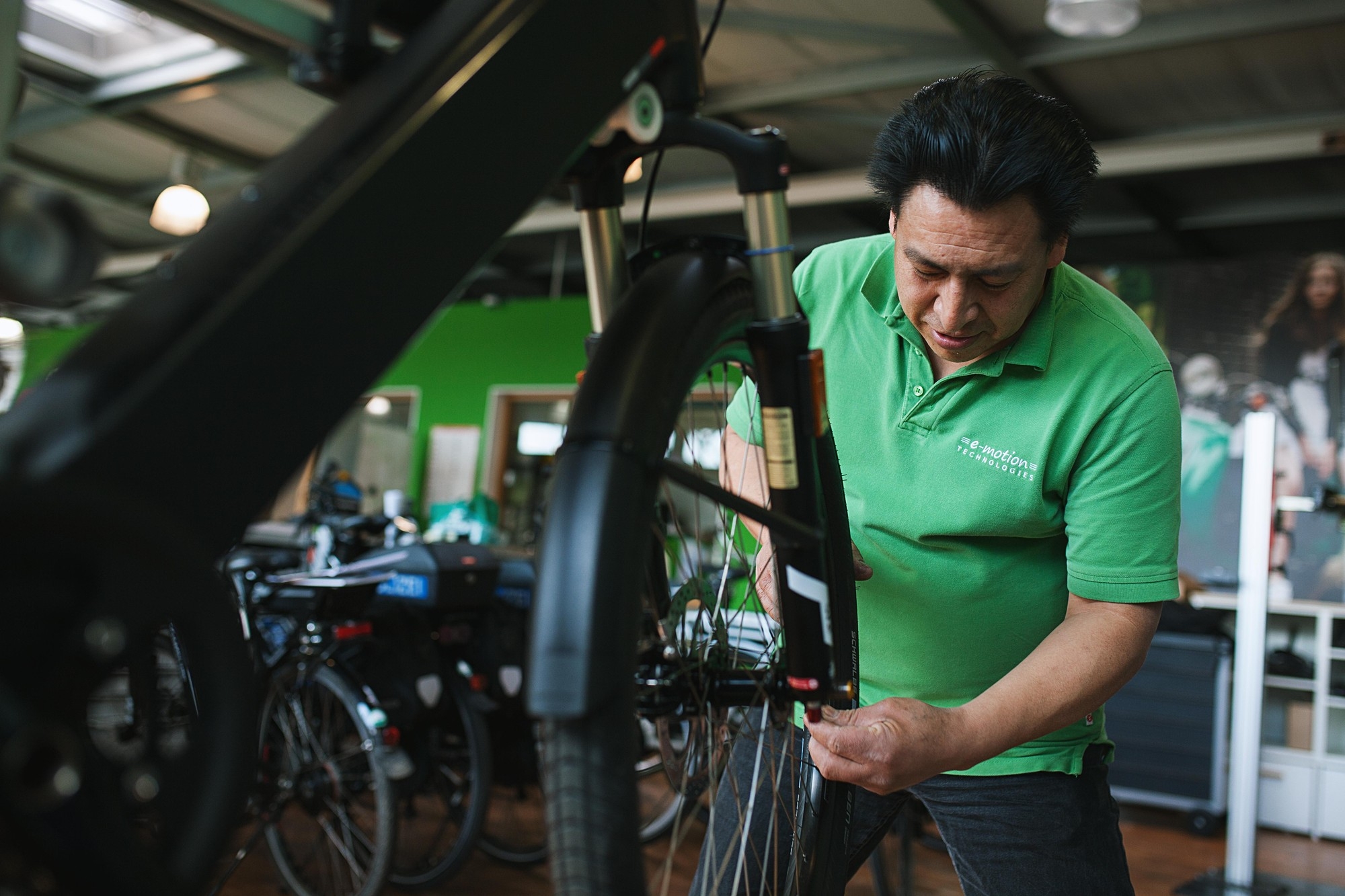 Mitarbeiter der e-motion e-bike Welt in Düsseldorf schraubt an einem Fahrrad.