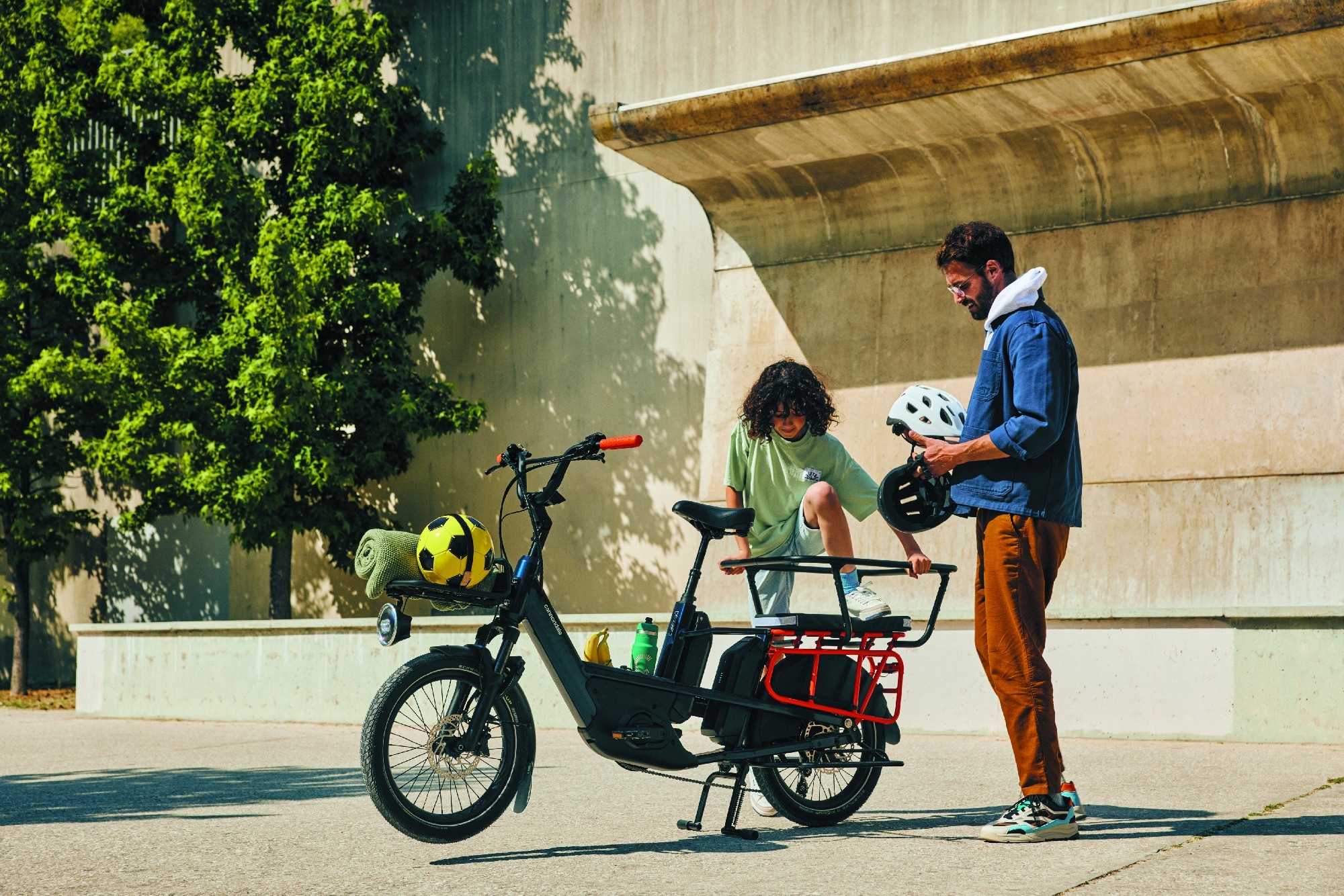 Ein Vater macht mit seinem Sohn auf dem Cannondale Cargo e-Bike einen Ausflug zum Fußballplatz.