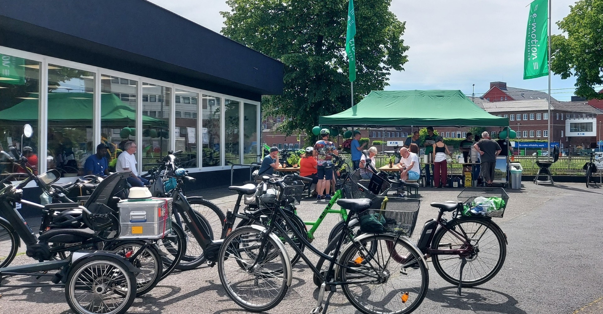 Besucherinnen und Besucher feiern die Eröffnung des neuen e-motion Standorts zwischen ausgestellten e-Bikes.